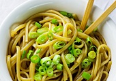 Bowl of Sesame Noodles with Sliced Scallions and Chopsticks