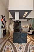 Hypermodern kitchen island with extractor hood in open-plan interior with ornamental terrazzo floor