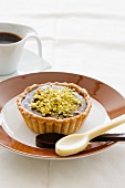 A chocolate tart topped with pistachios and halva