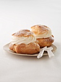 Two profiterole filled with cream on a plate