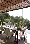 Dining area on roofed terrace with bamboo mat pergola
