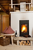 Gemütliche Stimmung mit Kaminfeuer in Stube einer renovierten Holzhütte