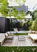 Seating area on terrace with wooden decking in front of modern city house