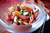 Fruit salad with pistachios, pomegranate seed and white almonds