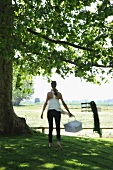 Woman with basket below tree