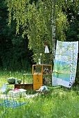Picknickdecke mit Stizkissen, Regal mit Wassermelonen und Holzscheiten und buntes Tuch als Windschutz im Garten