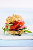 A wholemeal roll filled with salami, tomatoes and rocket