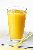 A glass of orange juice and a straw