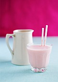Strawberry milkshake and a milk jug
