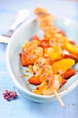 Prawn kebabs on a bed of peppers and fruit