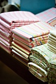 Striped and floral fabrics stacked on table