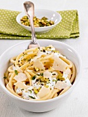 Macaroni with cheese sauce, pistachios and grated Parmesan