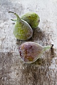 Three figs on a wooden surface