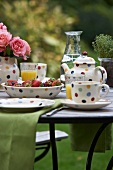 Breakfast laid in a garden with strawberries and orange juice
