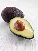 Halbierte und ganze Avocado