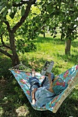 Shady spot in garden - woman reading in hammock