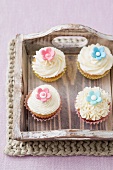 Four cupcakes on a wooden tray