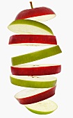 Flying slices of red and green apple