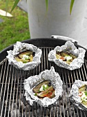 Sweet potatoes wrapped in foil on a barbecue