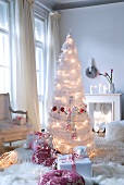 Christmas gift giving- artificial Christmas tree made from white feathers with lights and presents on flokati rug in traditional interior