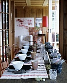 Festliche Tafel mit Leinen-Geschirrtüchern, Tellern, Schalen und beschrifteten Übertöpfen als Platzkärtchen
