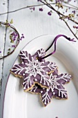 Snowflake-shaped biscuits decorated with purple icing sugar