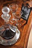 Glass decanter and liqueur glasses on antique wooden table
