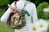 Woman carrying gardening tools in bag