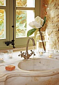 Mediterrane Badezimmer-Romantik - laufendes Wasser aus Retro Armatur in geschwungenes Marmorbecken