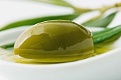 Green olive and oil in dish, close-up