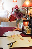 Brief und Stift neben Strauß mit Rosen