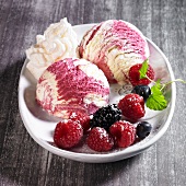Vanilla and berry ice cream with icing sugar, cream and lemon balm