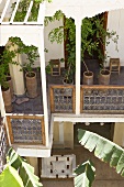 Bäume in Pflanzgefässen auf Laubengang eines mediterranen Wohnhauses und Blick in Innenhof