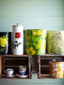 Colourful containers, planters and espresso cups in and on shelving