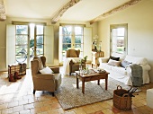 Simple interior with view of garden - wooden table between wingback chairs and couch in Mediterranean country house