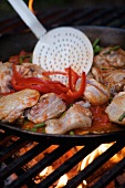 Paella in a large pan on an open fire
