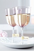 Wine glasses with names written on masking tape around the stem