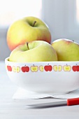 Masking Tape mit stilisiertem Apfelmotiv auf Porzellanschale mit drei Äpfeln