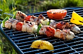Pork kebabs, pepper and tomatoes on a barbecue