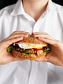 A young man holding a hamburger