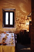 Gedeckter Tisch mit kleinen Schälchen in rustikalem Speisezimmer mit dramatischer Beleuchtung