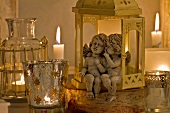 Angel figurines sitting in lantern and tea light holders with lit candles