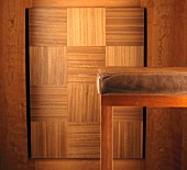 Barhocker mit braunem Lederbezug vor Holzwand