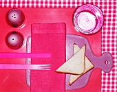 A pink place setting with toast triangles