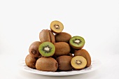 Golden and green kiwis stacked on a porcelain plate