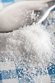 Stevia powder and a teaspoon on a checked surface