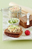 Egg salad spread with radishes, cucumber and herbs on wholemeal bread