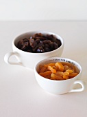 Dried apricots and dates in measuring cups