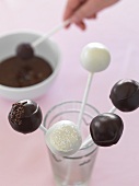 Cake pops being glazed with chocolate