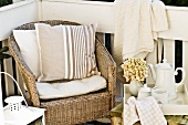 Afternoon break on veranda - wicker armchair with cushions next to tea service on side table